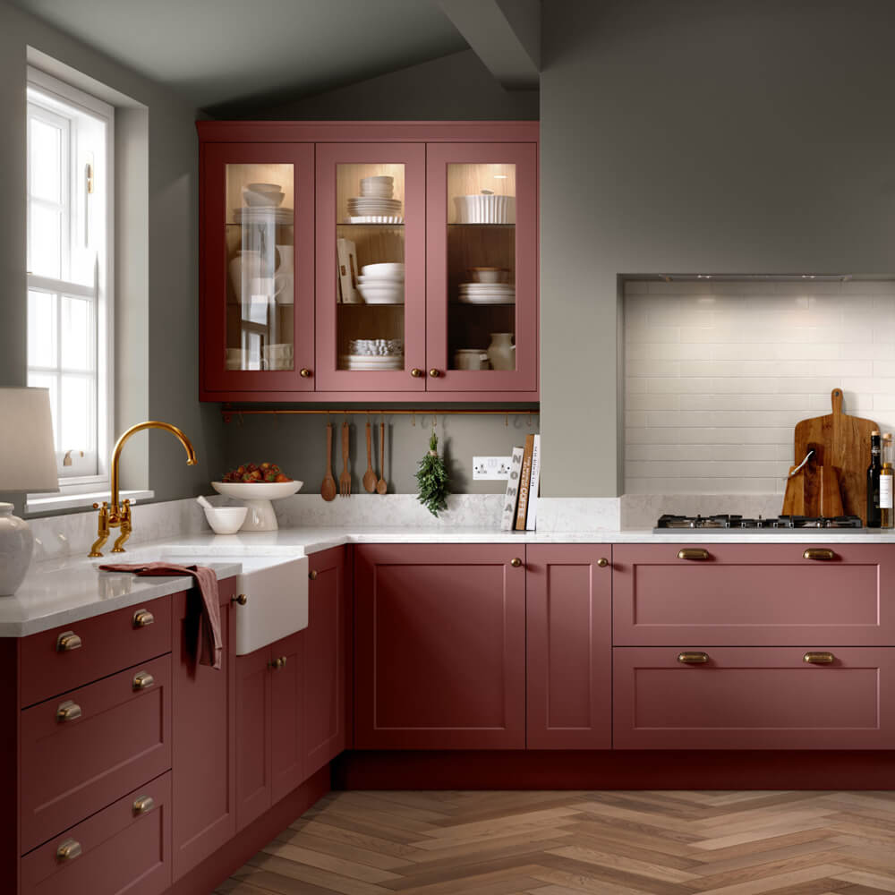 a stylish modern kitchen, featuring matte pink doors and gold furnishings